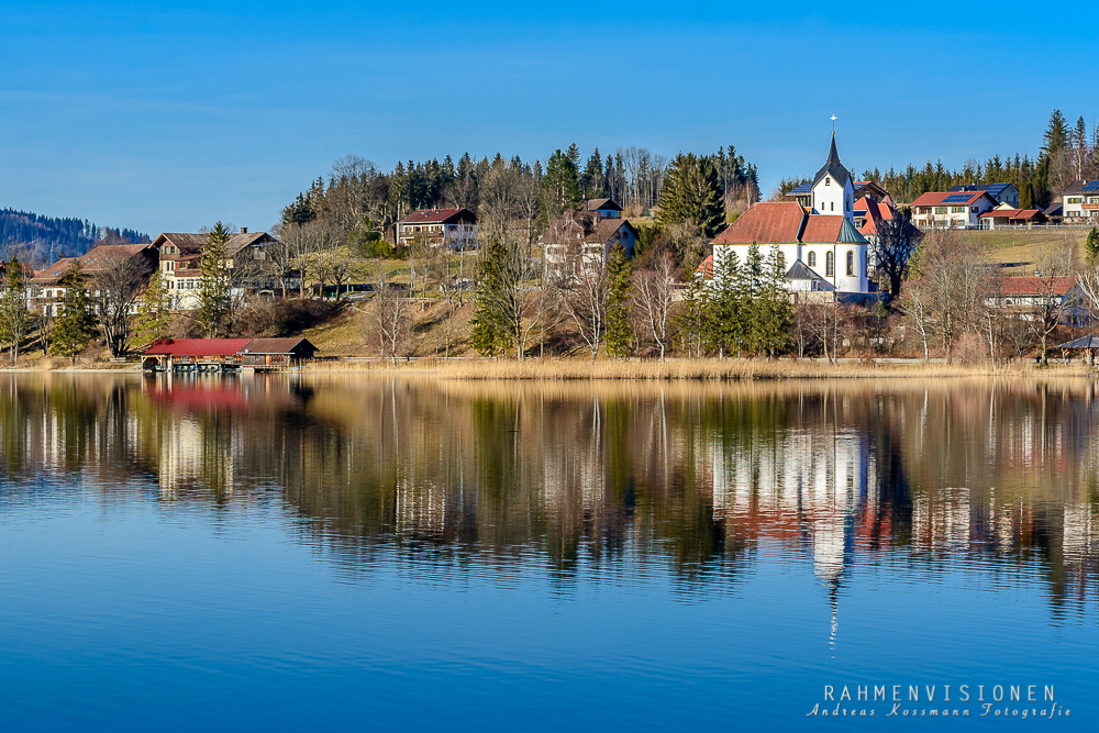 Kirche spiegelt sich im Weißensee